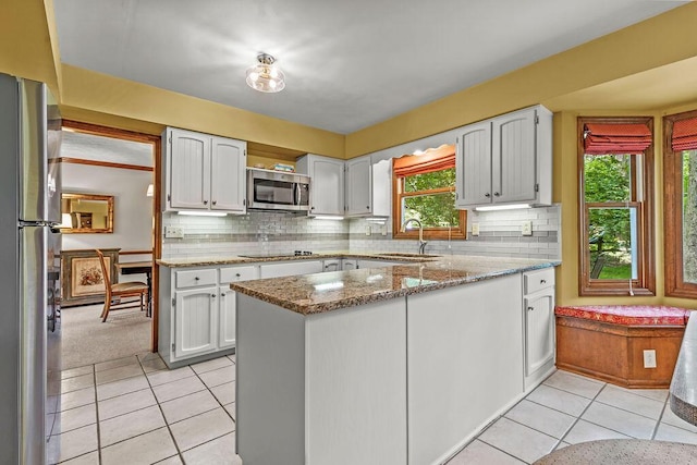 1212 Autumn Creek Cir, Westerville, OH 43081 - kitchen with stainless steel appliances, healthy amount of natural light, light tile patterned flooring, and a peninsula