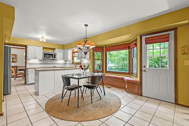 1212 Autumn Creek Cir, Westerville, OH 43081 - dining area featuring light tile patterned floors, a chandelier, and plenty of natural light