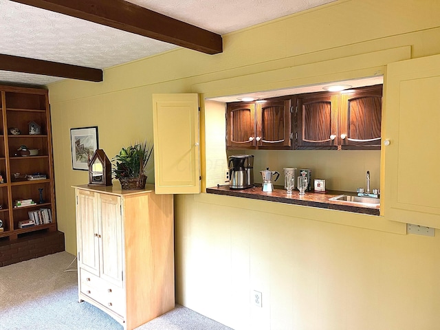 1212 Autumn Creek Cir, Westerville, OH 43081 - kitchen with beam ceiling, light carpet, a textured ceiling, and dark countertops