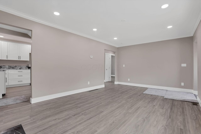 714 E 2nd St, Logan, OH 43138 - unfurnished living room with crown molding, light wood-type flooring, and recessed lighting