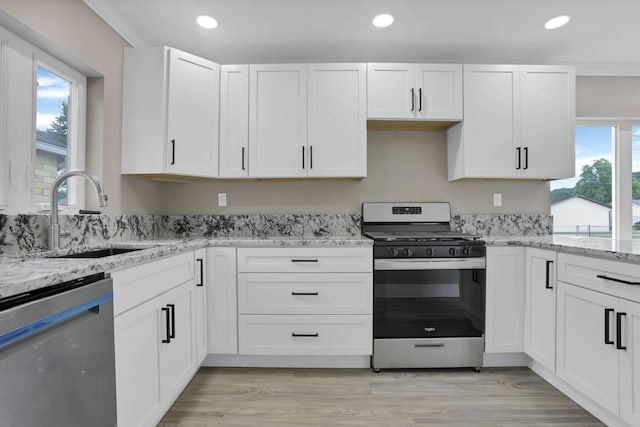 714 E 2nd St, Logan, OH 43138 - kitchen with stainless steel appliances, white cabinets, light stone countertops, recessed lighting, and light wood-style floors