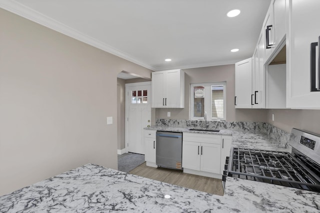 714 E 2nd St, Logan, OH 43138 - kitchen with appliances with stainless steel finishes, crown molding, light stone countertops, white cabinets, and light wood-style flooring