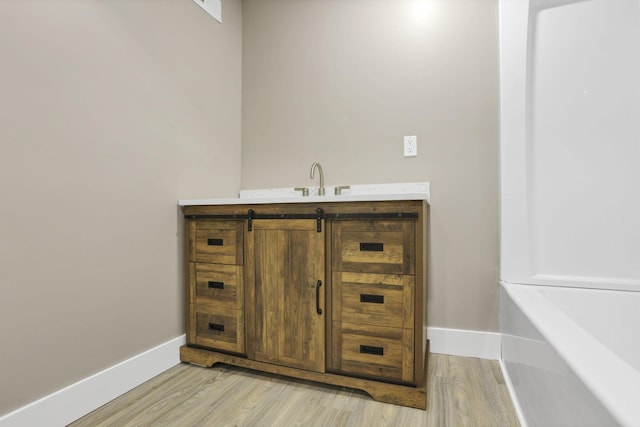 714 E 2nd St, Logan, OH 43138 - full bath featuring wood finished floors, a bath, and vanity