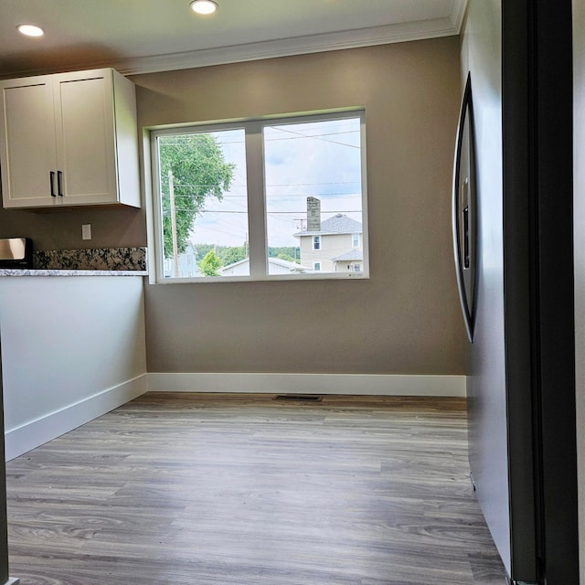 714 E 2nd St, Logan, OH 43138 - kitchen with freestanding refrigerator, ornamental molding, recessed lighting, white cabinetry, and light wood finished floors