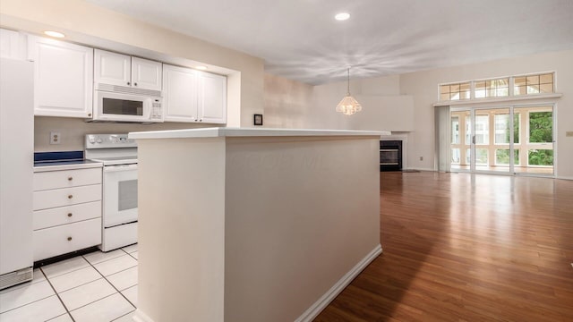 1486 Sedgefield Dr, New Albany, OH 43054 - kitchen featuring white appliances, light wood-style flooring, white cabinets, a glass covered fireplace, and light countertops