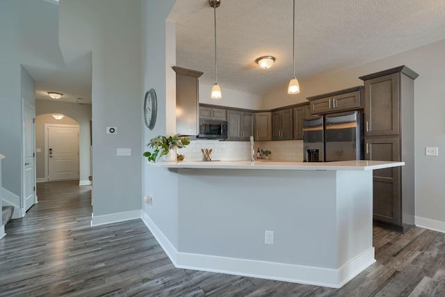 1957 Cumberland St, Newark, OH 43055 - kitchen with stainless steel appliances, arched walkways, light countertops, dark wood-style floors, and backsplash