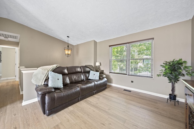 7603 Charlesway Dr Unit 87, Columbus, OH 43085 - living room with light wood-style floors, a textured ceiling, and vaulted ceiling