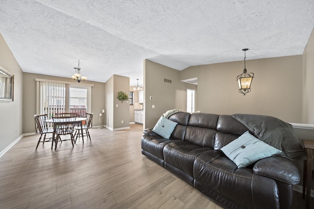7603 Charlesway Dr Unit 87, Columbus, OH 43085 - living area with a chandelier, light wood finished floors, a textured ceiling, and lofted ceiling