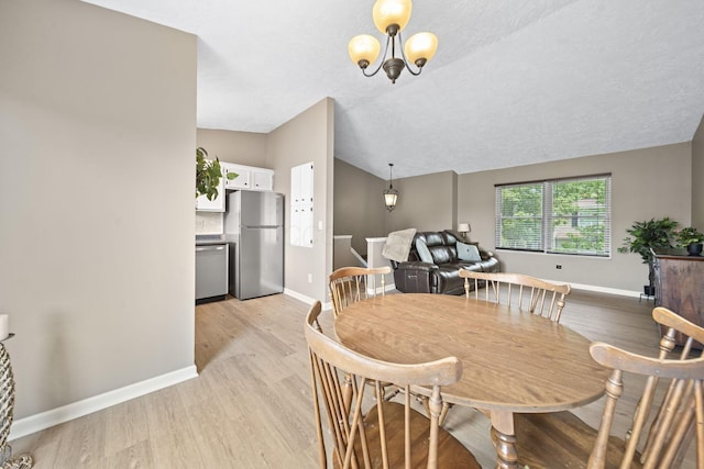 7603 Charlesway Dr Unit 87, Columbus, OH 43085 - dining space with lofted ceiling, light wood finished floors, a chandelier, and a textured ceiling