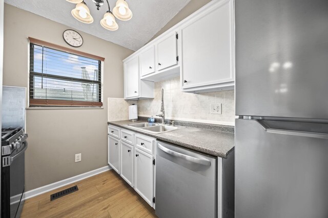 7603 Charlesway Dr Unit 87, Columbus, OH 43085 - kitchen featuring appliances with stainless steel finishes, backsplash, a chandelier, light wood-type flooring, and dark countertops