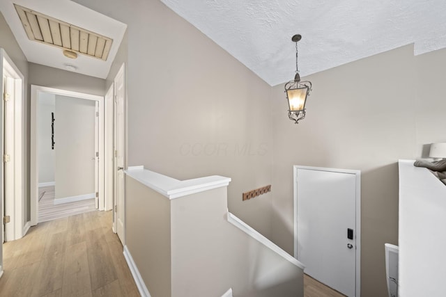 7603 Charlesway Dr Unit 87, Columbus, OH 43085 - hall with an upstairs landing, light wood-type flooring, and a textured ceiling