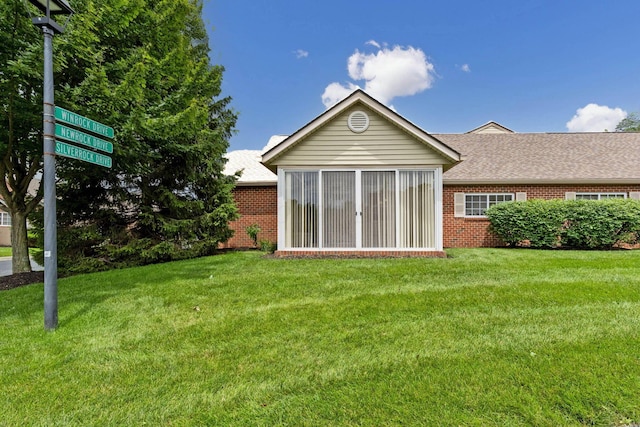 6858 Winrock Dr, New Albany, OH 43054 - rear view of house with brick siding, a lawn, and a shingled roof
