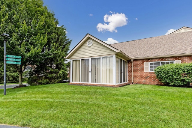 6858 Winrock Dr, New Albany, OH 43054 - back of house with brick siding, a sunroom, roof with shingles, and a yard