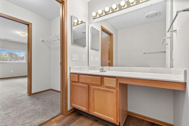 6858 Winrock Dr, New Albany, OH 43054 - bathroom with vanity, a textured ceiling, and wood finished floors