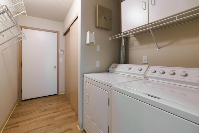 9427 Clermont Cir, Powell, OH 43065 - laundry area featuring independent washer and dryer, light wood-style flooring, and a textured ceiling