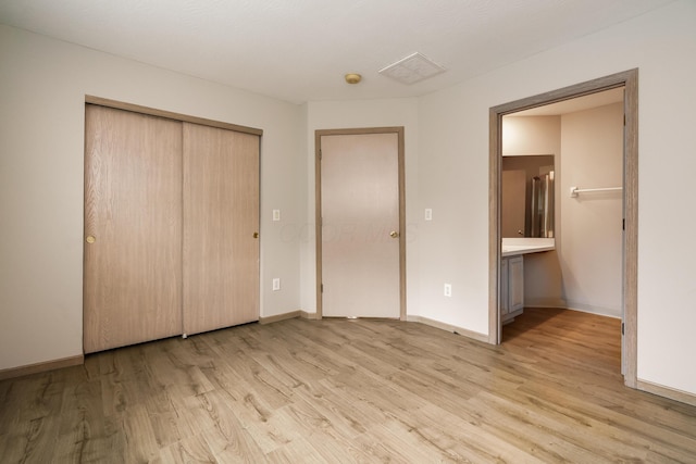 9427 Clermont Cir, Powell, OH 43065 - unfurnished bedroom featuring light wood-style flooring, a closet, and ensuite bath