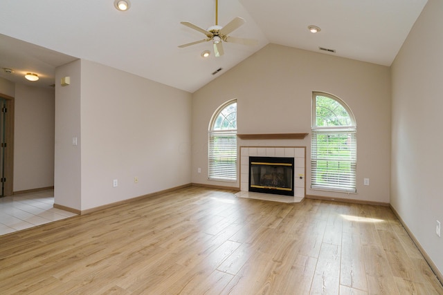 9427 Clermont Cir, Powell, OH 43065 - unfurnished living room featuring ceiling fan, healthy amount of natural light, light wood-style floors, a tile fireplace, and high vaulted ceiling