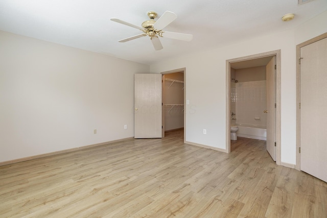 9427 Clermont Cir, Powell, OH 43065 - unfurnished bedroom featuring light wood-style floors, a walk in closet, ensuite bathroom, and ceiling fan