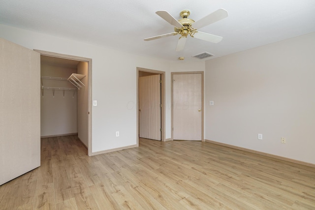 9427 Clermont Cir, Powell, OH 43065 - unfurnished bedroom with light wood-style flooring, attic access, a ceiling fan, and a walk in closet