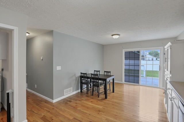 5010 Nelson Dr, South Bloomfield, OH 43103 - dining room with light wood-style flooring, baseboards, and a textured ceiling