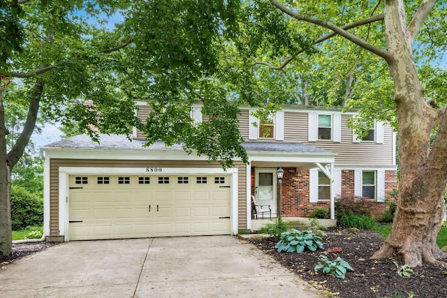 8800 Greenburg Dr, Powell, OH 43065 - traditional-style house featuring driveway, a garage, and brick siding