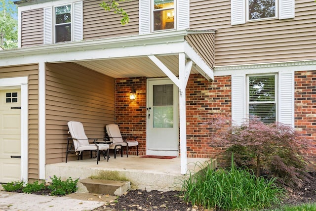 8800 Greenburg Dr, Powell, OH 43065 - doorway to property with a porch, brick siding, and a garage