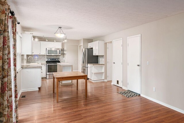 8800 Greenburg Dr, Powell, OH 43065 - kitchen featuring stainless steel appliances, light wood-type flooring, a sink, light countertops, and tasteful backsplash