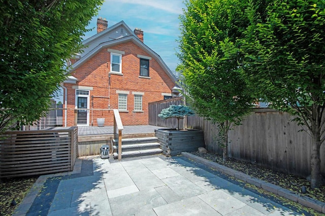 193 E Mithoff St Unit 193, Columbus, OH 43206 - rear view of property featuring a chimney, brick siding, a patio, and a fenced backyard