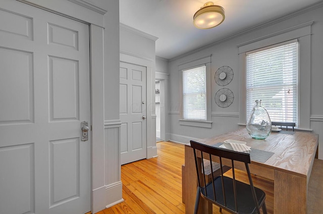 193 E Mithoff St Unit 193, Columbus, OH 43206 - dining space featuring crown molding, light wood-style floors, wainscoting, a desk, and a decorative wall