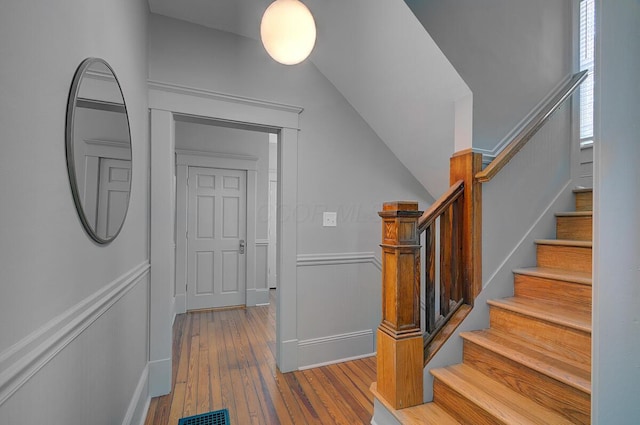 193 E Mithoff St Unit 193, Columbus, OH 43206 - stairs featuring wood finished floors, a decorative wall, a wainscoted wall, and lofted ceiling