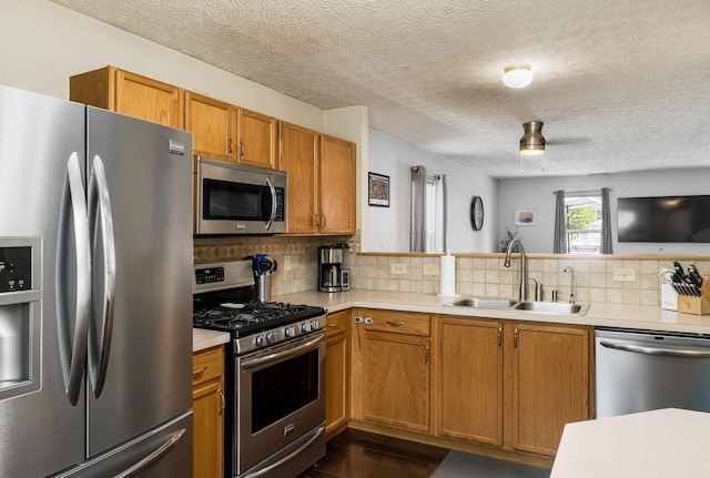 7524 Hemrich Dr, Canal Winchester, OH 43110 - kitchen featuring appliances with stainless steel finishes, light countertops, backsplash, brown cabinetry, and a textured ceiling