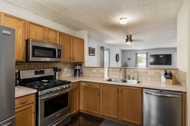 7524 Hemrich Dr, Canal Winchester, OH 43110 - kitchen with appliances with stainless steel finishes, light countertops, tasteful backsplash, dark wood-type flooring, and a textured ceiling
