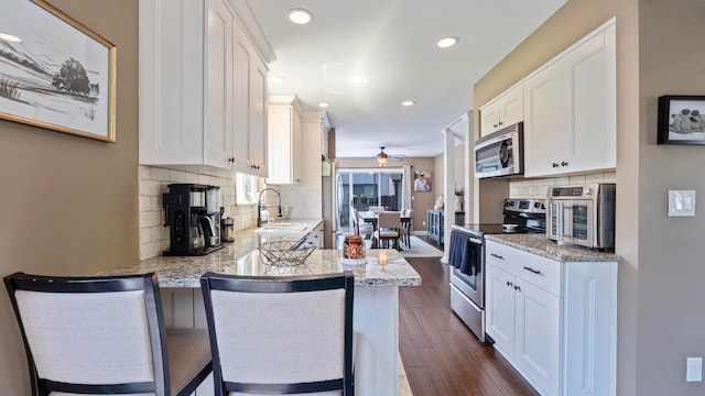 5225 Springdale Blvd, Hilliard, OH 43026 - kitchen with stainless steel appliances, white cabinetry, backsplash, a ceiling fan, and recessed lighting