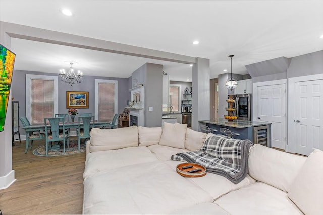 1167 Neil Ave, Columbus, OH 43201 - living room with wood finished floors, a chandelier, wine cooler, recessed lighting, and baseboards