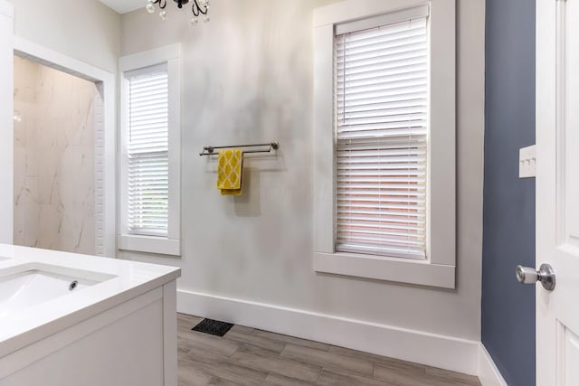 1167 Neil Ave, Columbus, OH 43201 - bathroom featuring vanity, a chandelier, wood finished floors, and baseboards