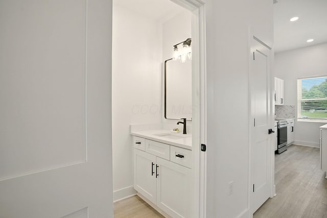 92 E Innis Ave, Columbus, OH 43207 - bathroom with wood finished floors, vanity, backsplash, and recessed lighting