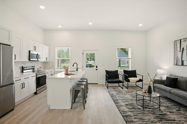 92 E Innis Ave, Columbus, OH 43207 - kitchen with stainless steel appliances, a kitchen breakfast bar, open floor plan, tasteful backsplash, and a center island with sink