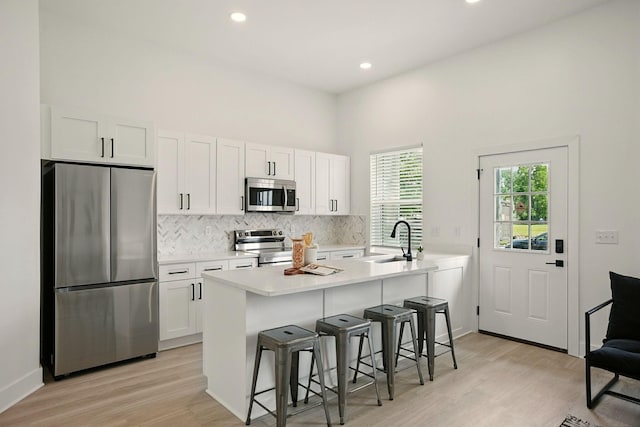 92 E Innis Ave, Columbus, OH 43207 - kitchen with appliances with stainless steel finishes, decorative backsplash, light wood-style floors, white cabinets, and recessed lighting