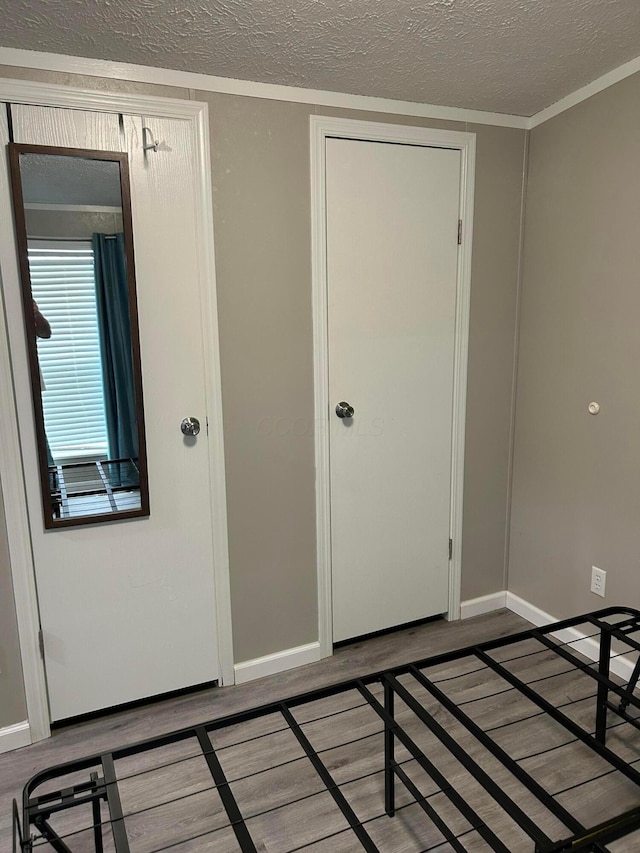 5019 N High St Unit 97, Columbus, OH 43214 - unfurnished bedroom featuring baseboards, wood finished floors, and a textured ceiling