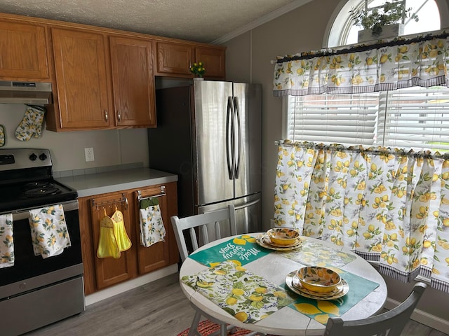 5019 N High St Unit 97, Columbus, OH 43214 - kitchen with appliances with stainless steel finishes, under cabinet range hood, healthy amount of natural light, light wood finished floors, and crown molding