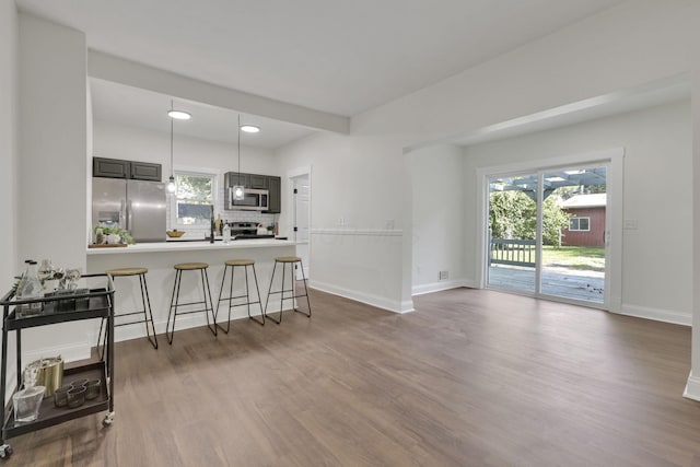 638 E 6th Ave, Lancaster, OH 43130 - kitchen with stainless steel appliances, wood finished floors, a breakfast bar area, backsplash, and a peninsula