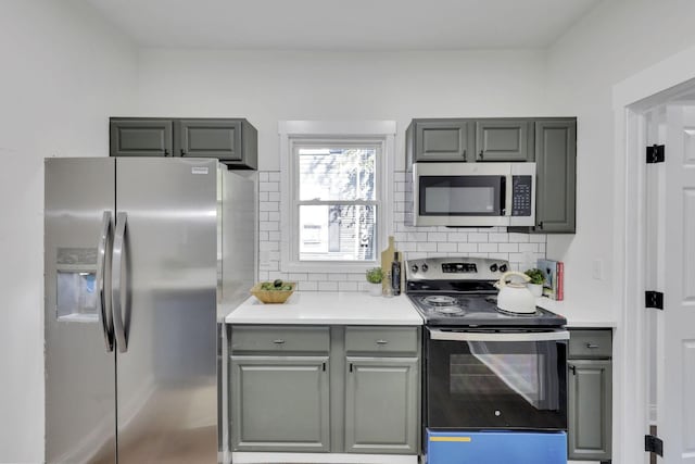 638 E 6th Ave, Lancaster, OH 43130 - kitchen featuring appliances with stainless steel finishes, gray cabinetry, and tasteful backsplash