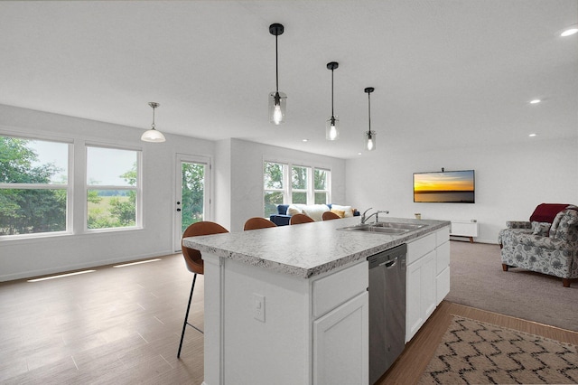 120 Heron Ave, Pataskala, OH 43062 - kitchen featuring stainless steel dishwasher, open floor plan, wood finished floors, a center island with sink, and a breakfast bar