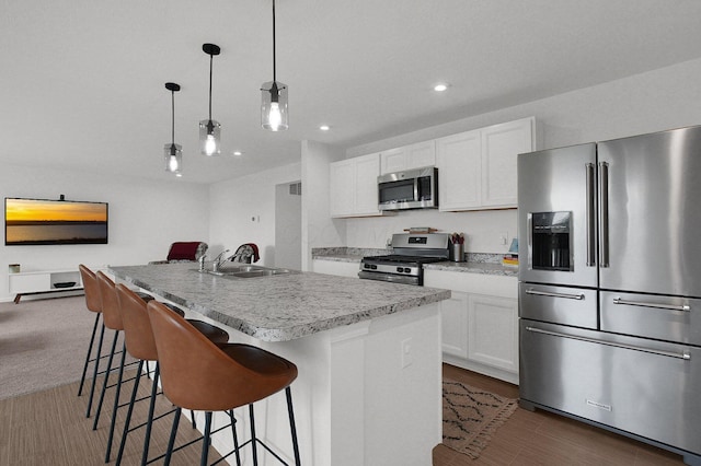 120 Heron Ave, Pataskala, OH 43062 - kitchen featuring appliances with stainless steel finishes, recessed lighting, white cabinetry, a center island with sink, and a breakfast bar