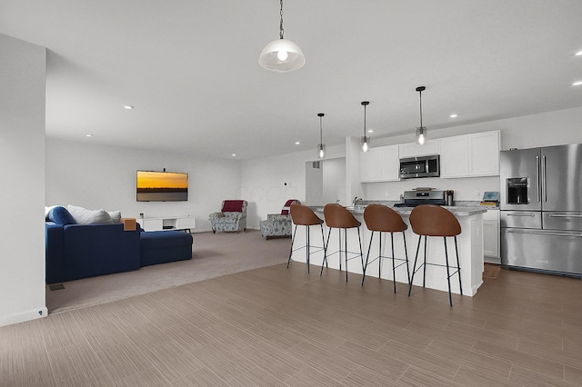 120 Heron Ave, Pataskala, OH 43062 - kitchen with stainless steel appliances, open floor plan, a kitchen bar, white cabinets, and recessed lighting