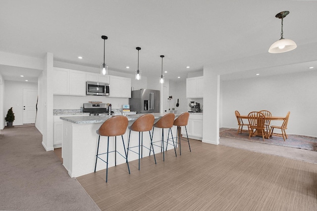 120 Heron Ave, Pataskala, OH 43062 - kitchen with stainless steel appliances, recessed lighting, a kitchen island with sink, white cabinets, and light countertops
