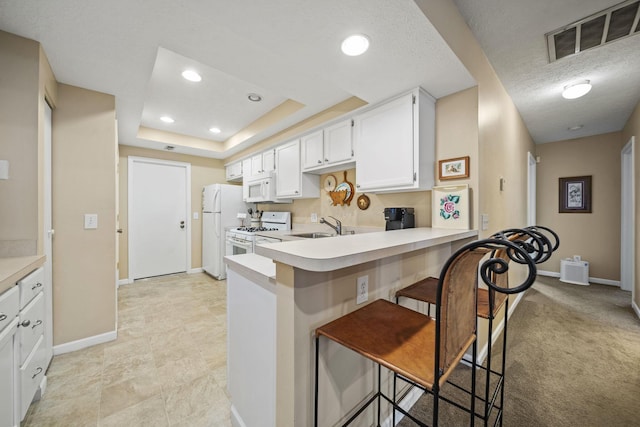 305 Pointe Pl Unit 12, Westerville, OH 43082 - kitchen with white appliances, baseboards, a peninsula, light countertops, and a kitchen breakfast bar