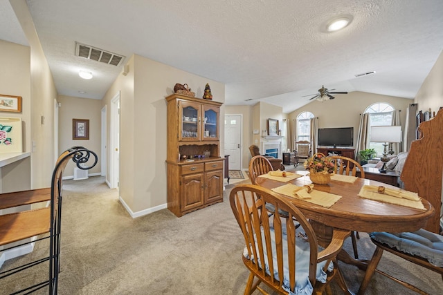 305 Pointe Pl Unit 12, Westerville, OH 43082 - dining room featuring a textured ceiling, a ceiling fan, light carpet, a fireplace, and vaulted ceiling