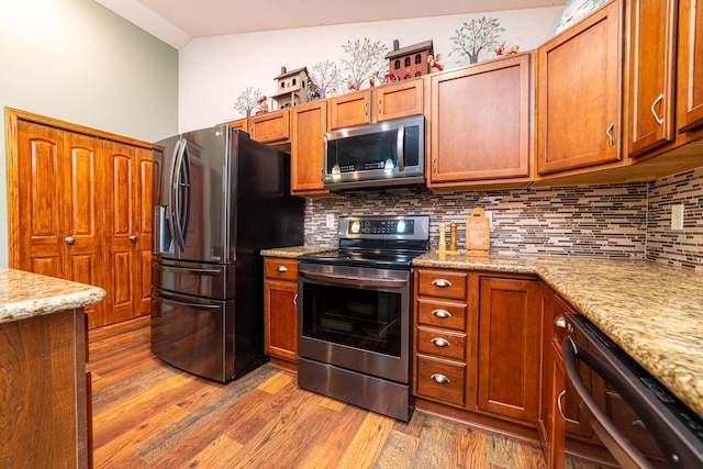 4091 Township Road 21, Marengo, OH 43334 - kitchen with appliances with stainless steel finishes, light wood-style floors, tasteful backsplash, and brown cabinetry