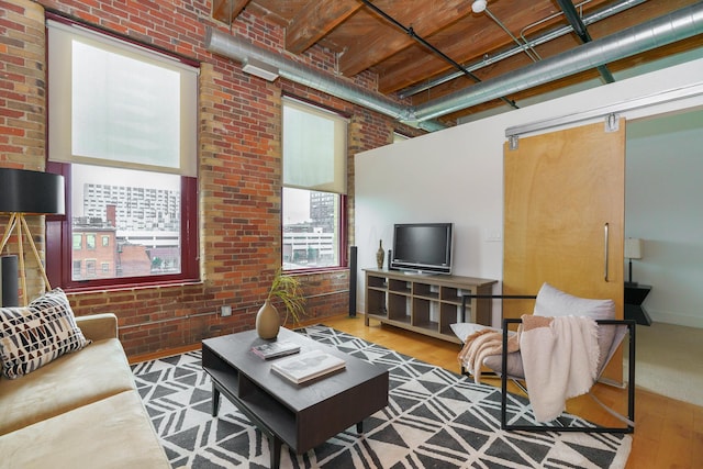 150 E Main St Unit 405, Columbus, OH 43215 - living area featuring brick wall, wood finished floors, and a towering ceiling